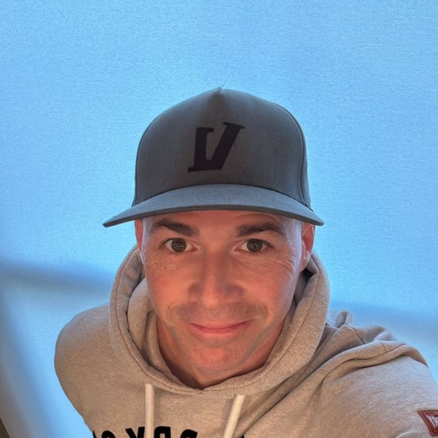 Grayscale selfie of Jonathan in a ball cap